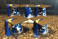 graduation caps and tassels are arranged in the middle of a display case on a granite countertop