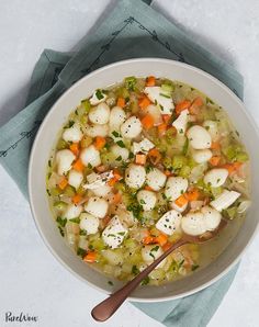 a white bowl filled with soup on top of a blue napkin