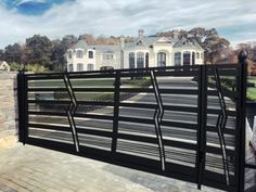 a black gate is in front of a large house