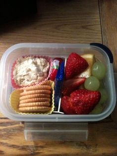 a plastic container filled with fruit and crackers