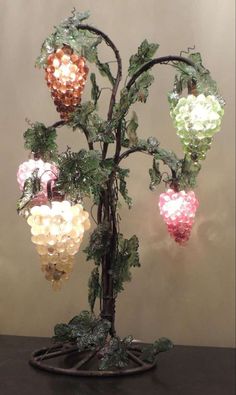 a lighted tree with fruit hanging from it's branches and lights on the top