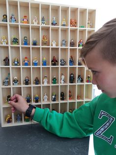 a young boy is playing with legos in a toy store display case on the table