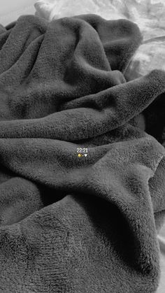 a black and white photo of a blanket on a bed