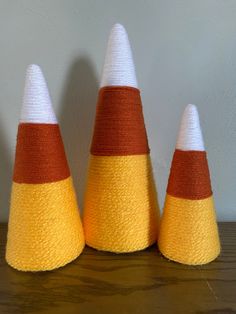 three orange and white cones sitting on top of a wooden table