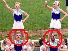 two girls in cheerleader outfits standing on one another's shoulders with their hands up