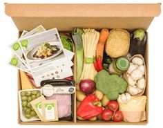 an open cardboard box filled with assorted vegetables