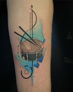 a tattoo with a drum and arrows on it