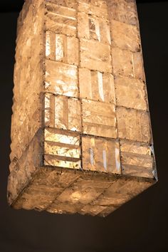 a light that is hanging from the ceiling in front of a black wall and floor