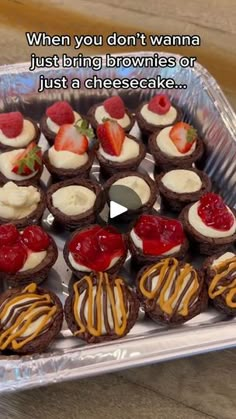 a tray filled with cupcakes covered in frosting and strawberries