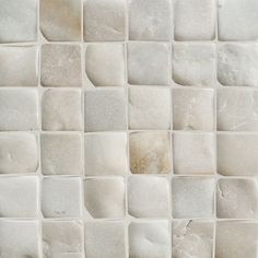 a close up view of a white tile wall