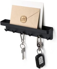 a black shelf with keys, envelope and keychain hanging from it's hooks