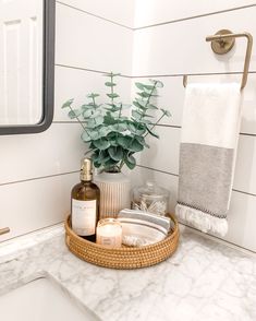 a bathroom sink with soap, lotion and candles on it