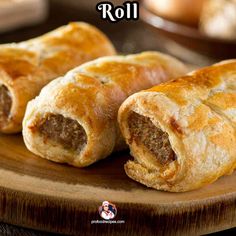 two sausage rolls sitting on top of a wooden cutting board with the words roll written above it