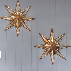 two gold stars hanging on the wall next to each other