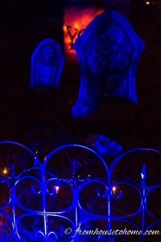 the cemetery is lit up with blue lights for halloween decorations, including tombstones and candles