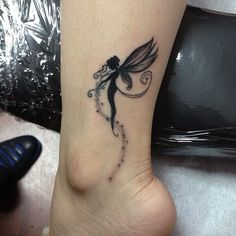 a woman's foot with a small tattoo on the side of her leg and a fairy