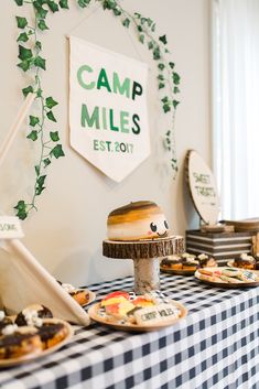 a table topped with lots of food next to a wall mounted sign that says camp miles