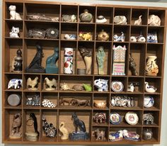 a wooden shelf filled with lots of different types of figurines on top of it