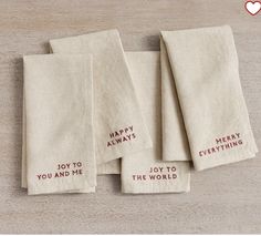 four embroidered napkins with words that say happy always you and me, joy to the world