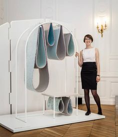 a woman standing in front of a white sculpture with blue and gray shapes on it