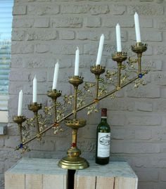 a candle holder with seven candles and a bottle of wine