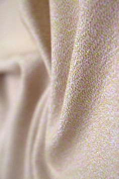 a close up view of a white fabric with small dots on it's surface