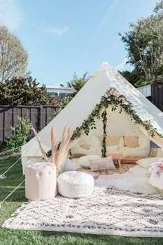 a teepee tent with pillows on the grass