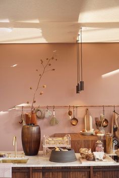 a kitchen counter with pots and pans hanging from it's hooks on the wall