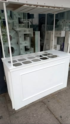 a white display case sitting on top of a sidewalk