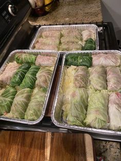 several trays filled with food sitting on top of a counter next to an oven