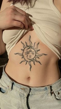 a woman with a sun and moon tattoo on her stomach