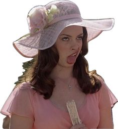 a woman in a pink dress and hat making a funny face with her tongue out