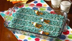 a glass dish filled with blue cake and marshmallows on a polka dot table cloth