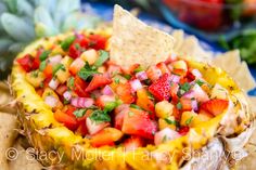 a fruit salsa in a pineapple shell with tortilla chips on the side