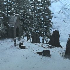 an old cemetery in the middle of a snow covered mountain with trees and rocks around it