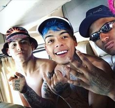 three shirtless men sitting in the back of a car with tattoos on their arms