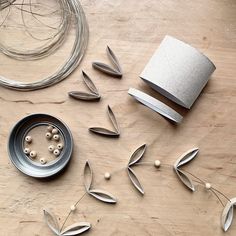 some metal objects sitting on top of a wooden table next to wire and bead