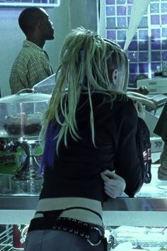 a woman with blonde hair standing in front of a counter