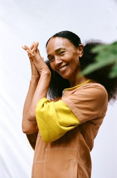 a woman with her hands together smiling