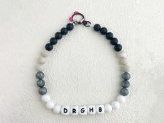 a beaded bracelet with the word dribb spelled in white and black beads