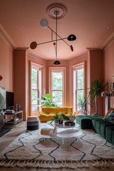 a living room filled with furniture and a large round table in front of two windows