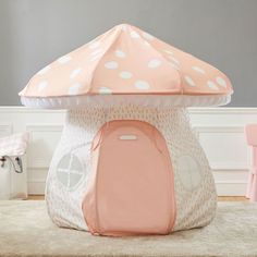 a pink and white polka dot umbrella shaped play tent in a child's room