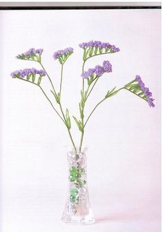 a glass vase filled with purple flowers on top of a table