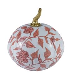 an orange and white pumpkin ornament with leaves on it's side, hanging from a gold - plated metal hook