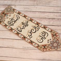 an old rug with arabic writing on it sitting on a wooden floor next to a wall