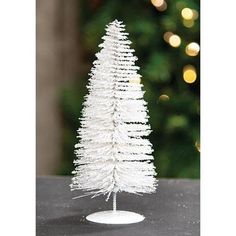 a small white christmas tree sitting on top of a table