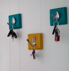 three hooks holding keys and spoons are attached to the wall with magnets on them