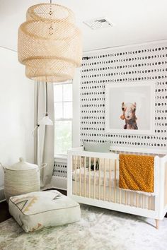 a baby's room with a crib, lamp and pictures on the wall