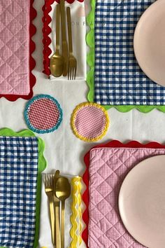 a table topped with plates and silverware on top of a checkered table cloth