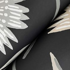 black and white wallpaper with large flower designs on it's side, close up